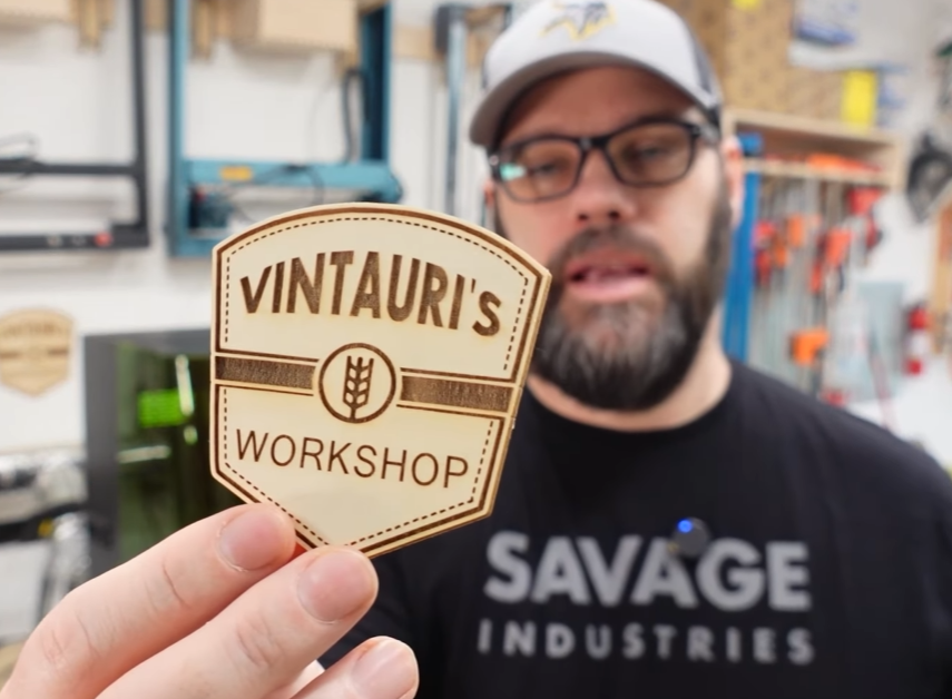 Person holding a laser engraved wooden badge created with a UV laser engraver